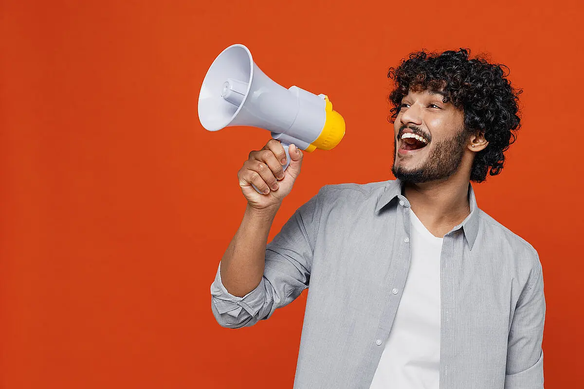 Mann mit Megafon bietet 10 gratis Unterrichtseinheiten bei iQ Lingua an